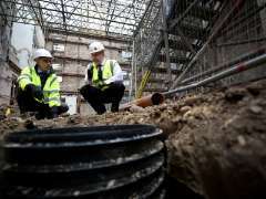 two people in high vis inspecting a building site